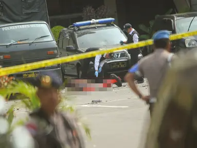 Polisi memeriksa jenazah seorang yang diduga sebagai pelaku bom bunuh diri di Mapolrestabes Medan, Sumatera Utara, Rabu (13/11/2019). Bom bunuh diri meledak di Mapolrestabes Medan sekitar pukul 08.45 WIB. (ATAR/AFP)