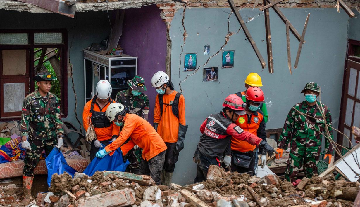 Operasi pencarian melibatkan personel gabungan dari unsur TNI, Polri, Basarnas, BPBD, relawan, dan masyarakat. Tampak dalam foto, tim penyelamat bersiap untuk mengeluarkan jenazah korban tewas dari puing-puing rumah yang hancur di lokasi longsor di Desa Situkung, Banjarnegara, Jawa Tengah, pada Rabu 19 November 2025. (DEVI RAHMAN/AFP)