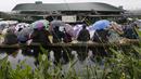 Antusias penonton  saat menyaksikan laga tenis Wimbledon dari layar tanpa mempedulikan hujan di The All England Lawn Tennis Club, London, (11/7/2017). (AP/Kirsty Wigglesworth)
