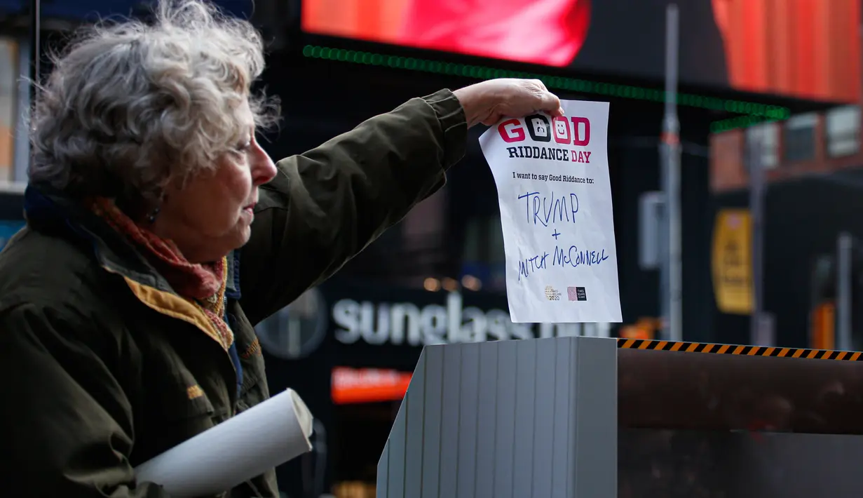 Seorang perempuan menghancurkan kertas berisi kenangan menyulitkan selama kegiatan Good Riddance Day ke-13 tahunan di Times Square, New York, 28 Desember 2019. Kegiatan menjelang tahun baru tersebut menjadi tradisi untuk menghapus kenangan buruk selama satu tahun. (Kena Betancur / AFP)