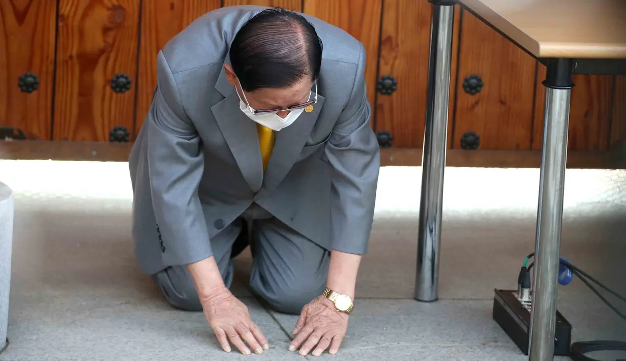 Pemimpin sekte Gereja Shincheonji Yesus, Lee Man-hee berlutut dan membungkuk untuk meminta maaf kepada publik saat konferensi pers di Gapyeong, Senin (2/3/2020). Pemimpin sekte tersebut meminta maaf karena jemaatnya menjadi penyebab penyebaran wabah virus corona di Korea Selatan. (POOL/AFP)