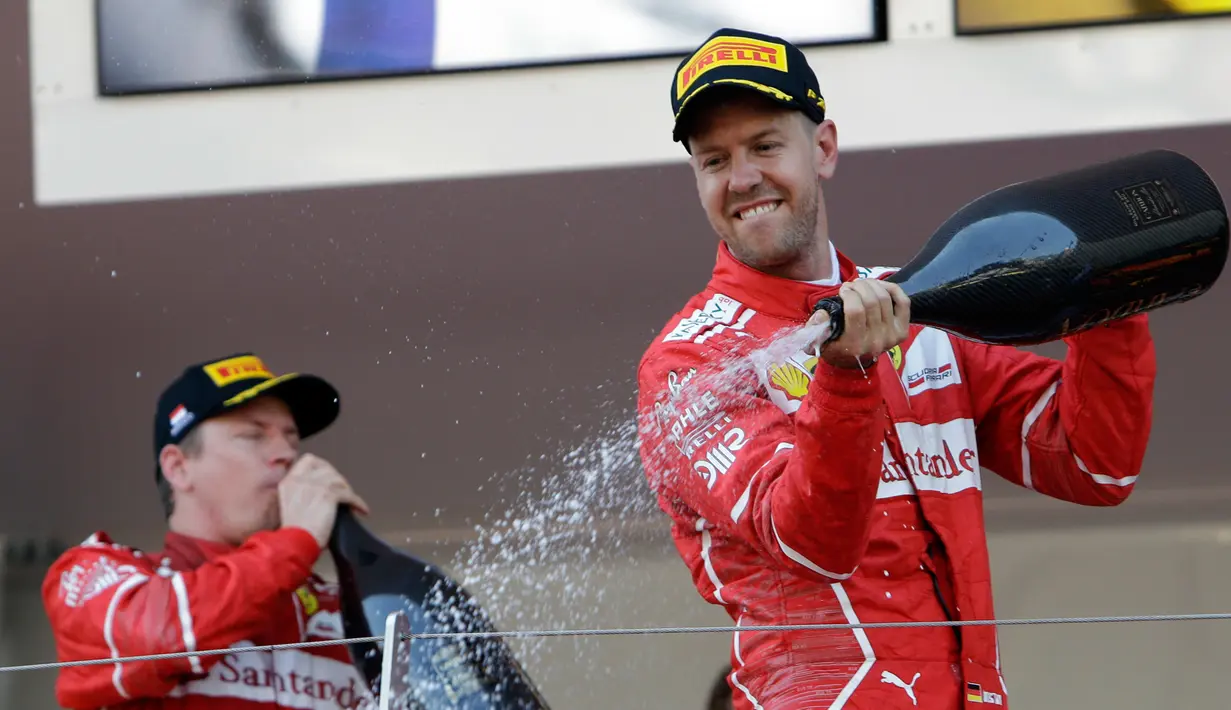 Pembalap Ferrari, Sebastian Vettel menyemprotkan sampanye saat merayakan kemenangannya pada balapan GP Monaco di Sirkuit Monte Carlo, Minggu (28/5). Vettel finis pada urutan pertama dengan waktu satu jam 44 menit 44,340 detik (AP Photo/Claude Paris)