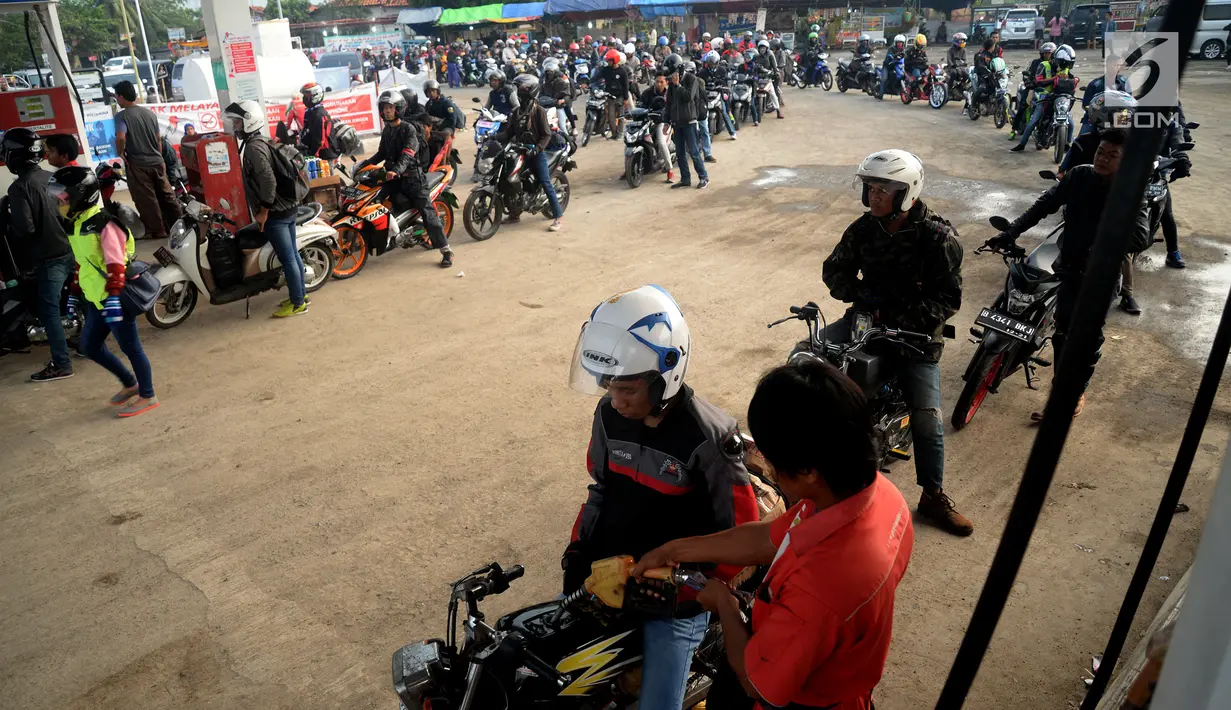 Pemudik sepeda motor mengantre BBM di SPBU Tulungangung, Indramayu, Jabar, Jumat (23/6). Tingginya volume kendaraan pemudik yang masuk membuat antrian menjadi panjang. (Liputan6.com/Johan Tallo)