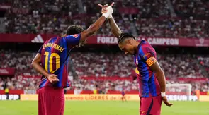 Raphinha dari Barcelona, ​​kanan, merayakan bersama Lamine Yamal setelah mencetak gol kedua timnya dalam pertandingan La Liga Spanyol antara Sevilla dan Barcelona di Seville, Spanyol, Minggu (20-9-2026) dini hari WIB. (AP Photo/Jose Breton)