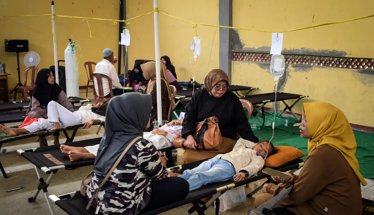 Murid-murid sekolah dasar mendapatkan perawatan di klinik darurat setelah mengalami keracunan usai menyantap makanan yang dibagikan lewat program Makan Bergizi Gratis di Bandung, Jawa Barat, pada 23 September 2025. (Timur Matahari/AFP)
