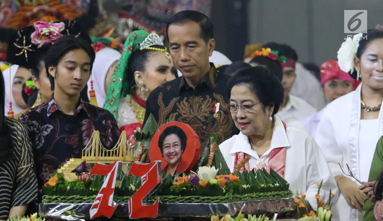 Ketua Umum PDIP Megawati Soekarnoputri memotong tumpeng pada HUT ke-72 didampingi Presiden Joko Widodo di Grand Sahid Jakarta, Rabu (23/1). Sejumlah politisi dan kader PDIP turut hadir dalam HUT ke-72 Megawati. (Liputan6.com/Angga Yuniar)