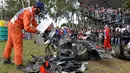 Seorang marshal mengosongkan kotak berisi puing mobil balap yang hancur akibat kecelakaan antara pembalap McLaren Fernando Alonso dan pembalap Haas, Esteban Gutierrez pada Formula 1 Grand Prix Australia di Melbourne, Minggu (20/3). (REUTERS/Joe Castro)