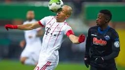 Pemain Bayern, Arjen Robben berusaha mengontrol bola dari kejaran pemian Paderborn, Adjei Antwi pada laga Piala DFB Pokal di Benteler-Arena, Paderborn, (6/2/2018). Bayern menang telak 6-0. (AFP/Patrik Stollarz)