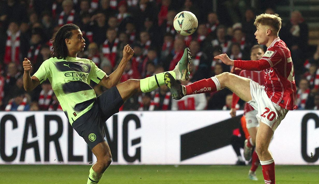 Pemain Manchester City, Nathan Ake (kiri) berebut bola dengan pemain Bristol City, Sam Bell pada laga putaran kelima Piala FA 2022/2023 di di Ashton Gate, Rabu (1/3/2023) WIB. Nathan Ake tampil apik dengan mampu membuat umpan-umpan terukur yang menghubungkan pertahanan dan serangan secara ringkas. (AFP/Adrian Dennis)