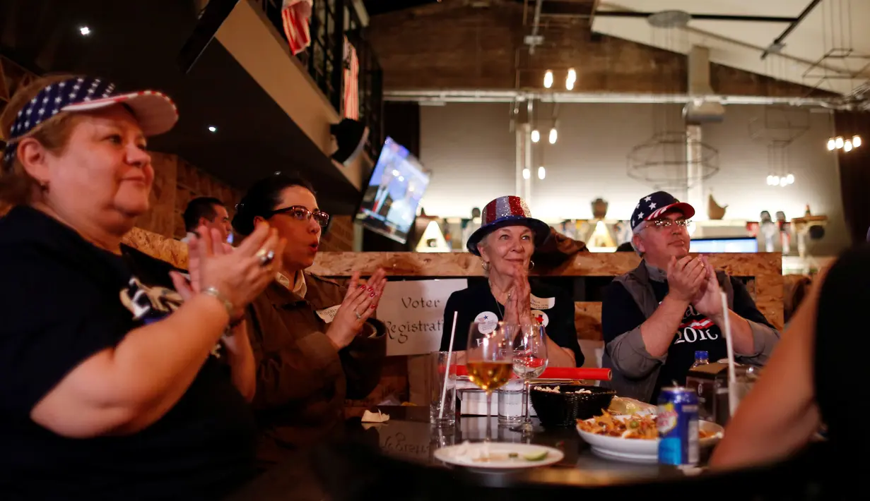 Pendukung Partai Demokrat terlihat serius menyaksikan debat Capres AS Donald Trump dan Hillary Clinton di Sebuah Restoran di Meksiko, (19/10). Menurut Consulta Mitofsky Mayoritas warga Meksiko cenderung mendukung Hillary Clinton. (Reuters/Carlos Jasso)