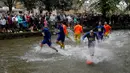 Keseruan saat para pemain Bourton Rovers bermain sepak bola dalam pertandingan tradisional tahunan di River Windrush. (AP Photo/Frank Augstein)