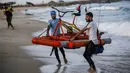 Nelayan Palestina membawa perahu kayuh yang dibuat khusus dari bahan daur ulang di sepanjang pantai di Beit Lahia, Jalur Gaza pada 29 September 2020. (Photo by MOHAMMED ABED / AFP)