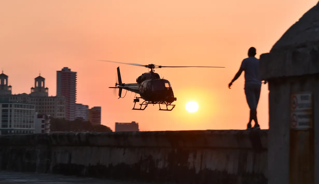 Helikopter milik Universal Studios Hollywood saat mengambil gambar selama pembuatan film Fast and Furious 8 di Havana, Kuba (28/4). Pembuatan film Fast & Furious 8 membuat warga Kuba antusias berdatangan ke lokasi syuting. (AFP PHOTO/ADALBERTO ROQUE)