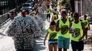 Peserta karnaval Bloco da Latinha berjalan berbaris di Madre de Deus, Brasil (9/2/2016). Anggota "Bloco da Latinha" ternyata mayoritas bekerja sebagai nelayan. (AFP Photo/Yasuyoshi Chiba)