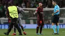 Petugas membawa seorang suporter yang mencium kaki kiri Lionel Messi saat pertandingan grup D Liga Champions melawan Sporting CP di stadion Alvalade, Lisbon, (27/9). (AP Foto/Armando Franca)