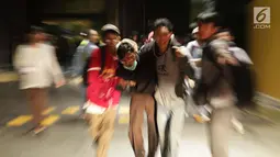 Sejumlah pelajar membantu rekan mereka yang terluka dalam demonstrasi berujung ricuh di Pejompongan, Jakarta, Rabu (25/9/2019). Sebelumnya, ribuan pelajar yang melangsungkan demonstrasi di Gedung DPR terlibat bentrok dengan polisi. (Liputan6.com/Helmi Fithriansyah)