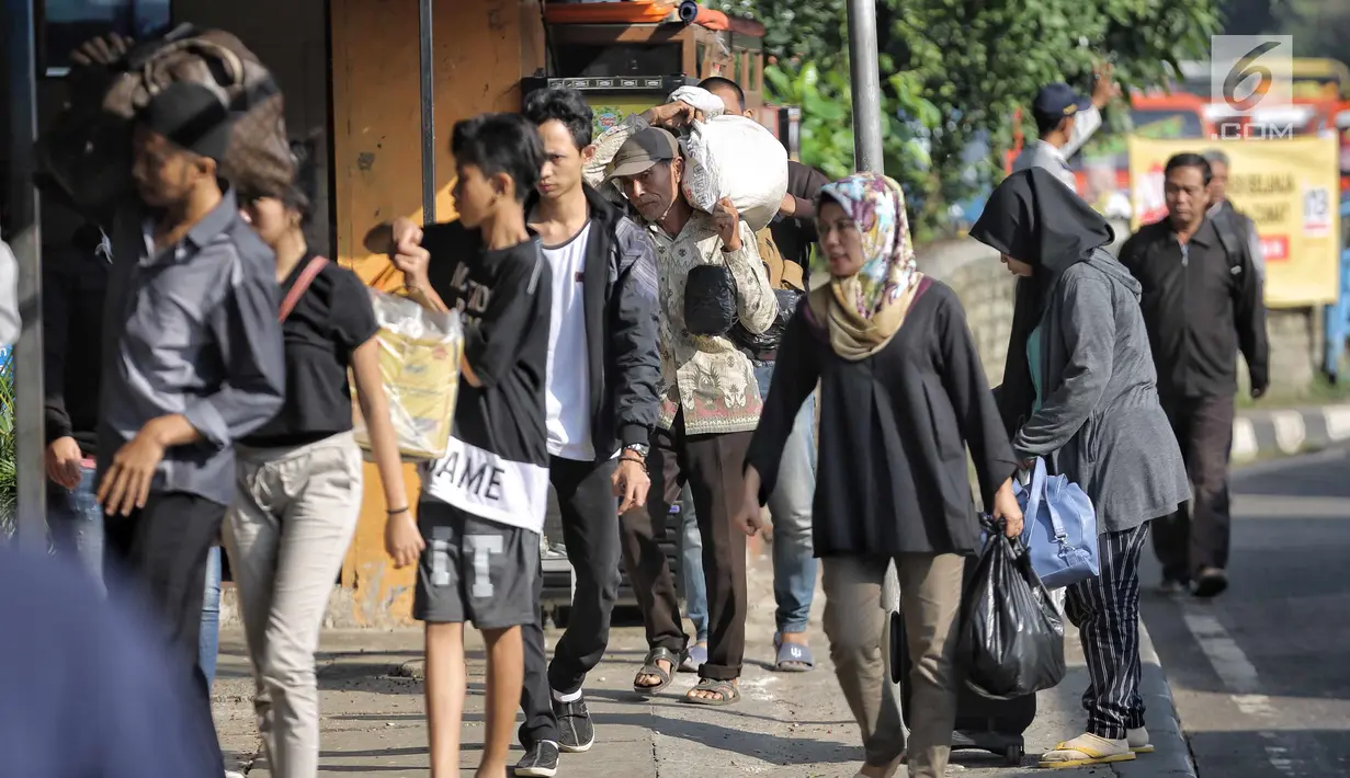 Penumpang berjalan usai turun dari bus Antar Kota Antar Provinsi di Terminal Kampung Rambutan, Jakarta, Selasa (19/6). Empat hari setelah Lebaran, jumlah penumpang yang tiba di Terminal Kampung Rambutan mencapai 17.492 orang. (Liputan6.com/Faizal Fanani