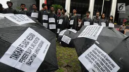 Sejumlah aktivis dari Gema Tapteng mengenakan pakaian serba hitam saat melakukan aksi unjuk rasa di depan gedung KPK, Jakarta, Kamis (26/4). Suap tersebut terkait sengketa Pilkada Tapanuli Tengah 2011 lalu. (Merdeka.com/Dwi Narwoko)