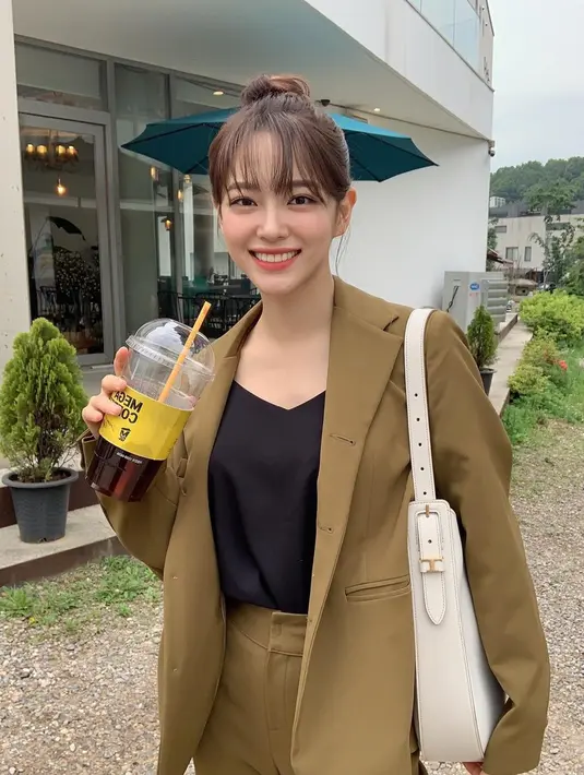 Gaya kasual Kim Sejeong dengan blouse hitam yang dipadukan dengan setelan blazer serta tas putih ini juga bisa dijadikan inspirasi. Bahkan, tatanan rambut buns dengan poni depan menambah kesan manis pada penampilannya. (Liputan6.com/IG/@clean_0828)