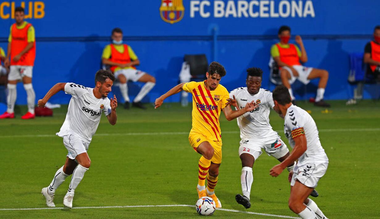 Pemain Barcelona, Trincao, berusaha melewati pemain Gimnastic pada laga uji coba di Johan Cruyff Stadium, Minggu (13/9/2020). Barcelona menang dengan skor 3-1. (AP/Joan Monfort)