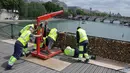 Sejumlah petugas saat memindahkan ribuan gembok cinta, dari sisi pembatas pagar Jembatan Pont des Arts di atas Sungai Seine, Paris, Perancis, Senin (1/6/2015). (REUTERS/Philippe Wojazer)