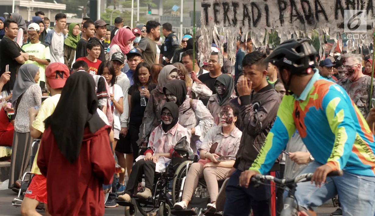 Penyandang disabilitas berkostum zombie berbaur dengan masyarakat saat melakukan aksi teatrikal untuk mengedukasi publik tentang persamaan dalam Festival Bebas Batas 2018 di CFD Jakarta, Minggu (14/10). (Merdeka.com/Iqbal Nugroho)