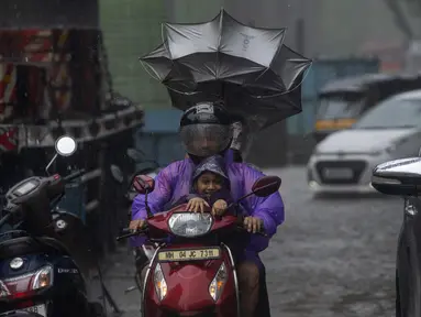 Pengendara melewati hujan di Mumbai, India, Minggu, 2 Juli 2023. Musim hujan India berlangsung Juni hingga September. (AP Photo/Rafiq Maqbool)