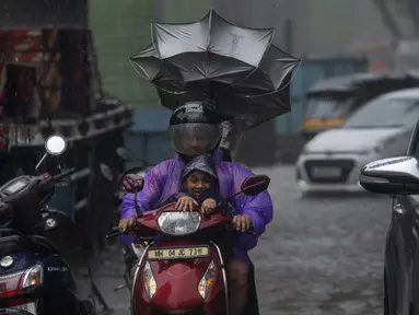 Pengendara melewati hujan di Mumbai, India, Minggu, 2 Juli 2023. Musim hujan India berlangsung Juni hingga September. (AP Photo/Rafiq Maqbool)