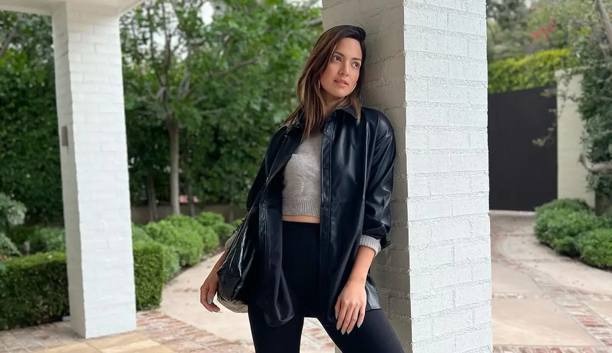 Konsisten membagikan inspirasi gaya midriff, kali ini Nia Ramadhani memadukan tiga potongan outfit yang terdiri dari leather jacket, crop top, dan high waisted pants. [Foto: IG/ramadhaniabakrie].