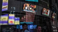 Layar televisi di New York Times Square menayangkan pertemuan bersejarah Donald Trump di Singapura. (AFP)