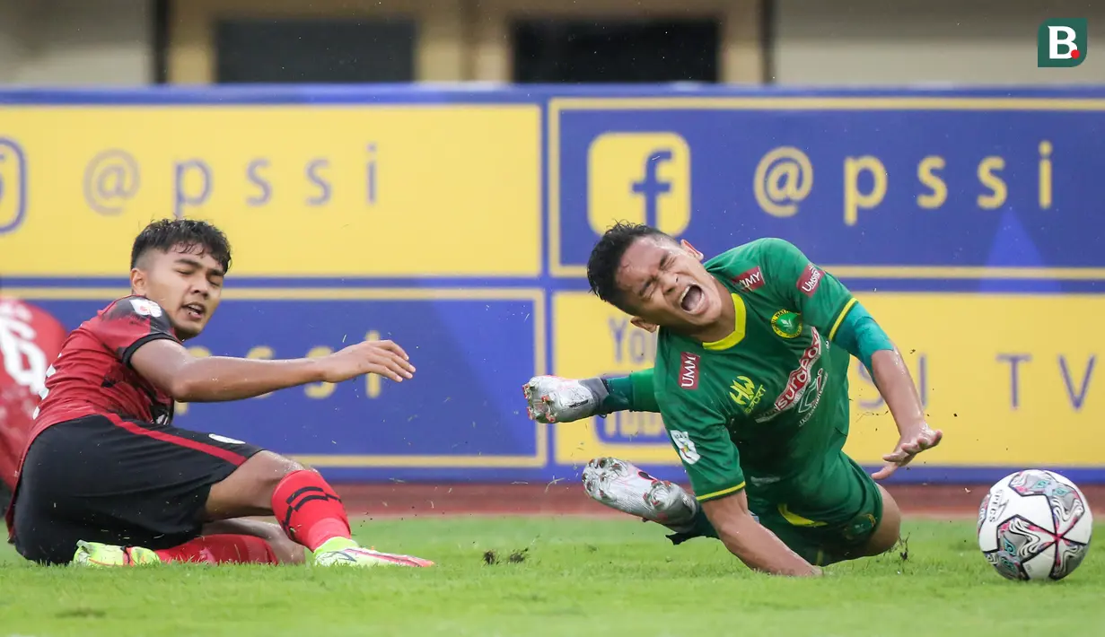 Pemain Hizbul Wathan FC, Vengko Armedya (kanan) meringis kesakitan usai dijatuhkan pemain PSG Pati, M Fayrushi dalam laga matchday ke-10 Grup C Liga 2 2021/2022 di Stadion Manahan, Solo, Selasa (30/11/2021). (Bola.com/Bagaskara Lazuardi)
