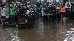 Pengendara sepeda motor terjebak banjir yang menggenangi kawasan Jalan Wolter Monginsidi Jakarta dan sekitarnya, Sabtu (20/2/2021). Hujan yang mengguyur Jakarta sejak Jumat (19/2) membuat sejumlah titik di Jakarta terendam banjir. (Liputan6.com/Helmi Fithriansyah)