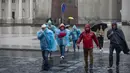 Orang-orang menyeberang jalan saat hari hujan, di Vilnius, Lituania, Senin (29/7/2024). (AP Photo/Mindaugas Kulbis)