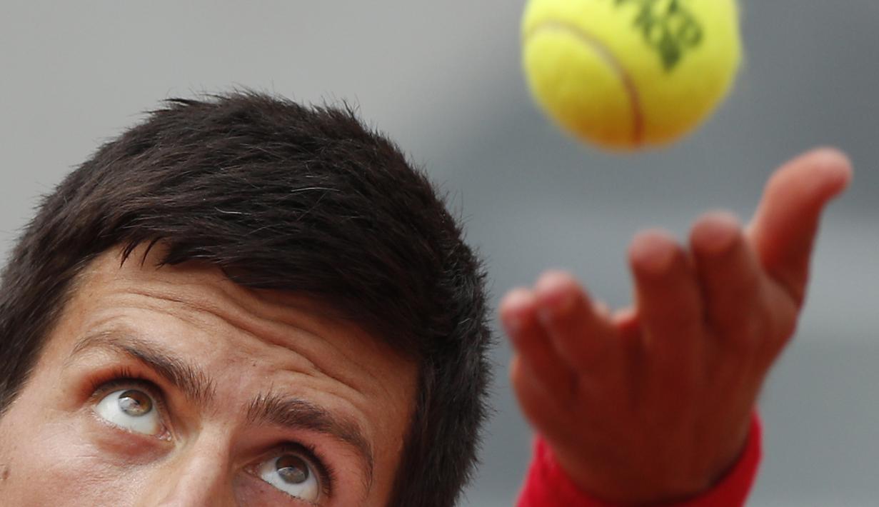 Ekspresi wajah petenis Serbia, Novak Djokovic melakukan servis saat melawan petenis Spanyol, Jaume Munar pada ajang Prancis Terbuka 2018 di Roland Garros stadium, Paris, France, (30/5/2018). (AP/Christophe Ena)