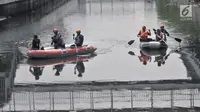 Tim gabungan menyusuri Kali Grogol untuk melakukan pencarian buaya di Jakarta Barat, Kamis (28/6). Untuk memancing buaya keluar dari persembunyiannya, petugas memberi umpan dengan dua ekor ayam dalam upaya penangkapannya. (Merdeka.com/Iqbal S. Nugroho)