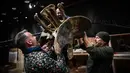 Pakar asal Italia merakit kerangka dinosaurus, Diplodocus dan Allosaurus sebelum mulai dilelang di Balai lelang Drouot, Paris, Jumat (6/4). Dua fosil hewan purbakala tersebut diperkirakan berusia 161 hingga 145 juta tahun. (STEPHANE DE SAKUTIN/AFP)