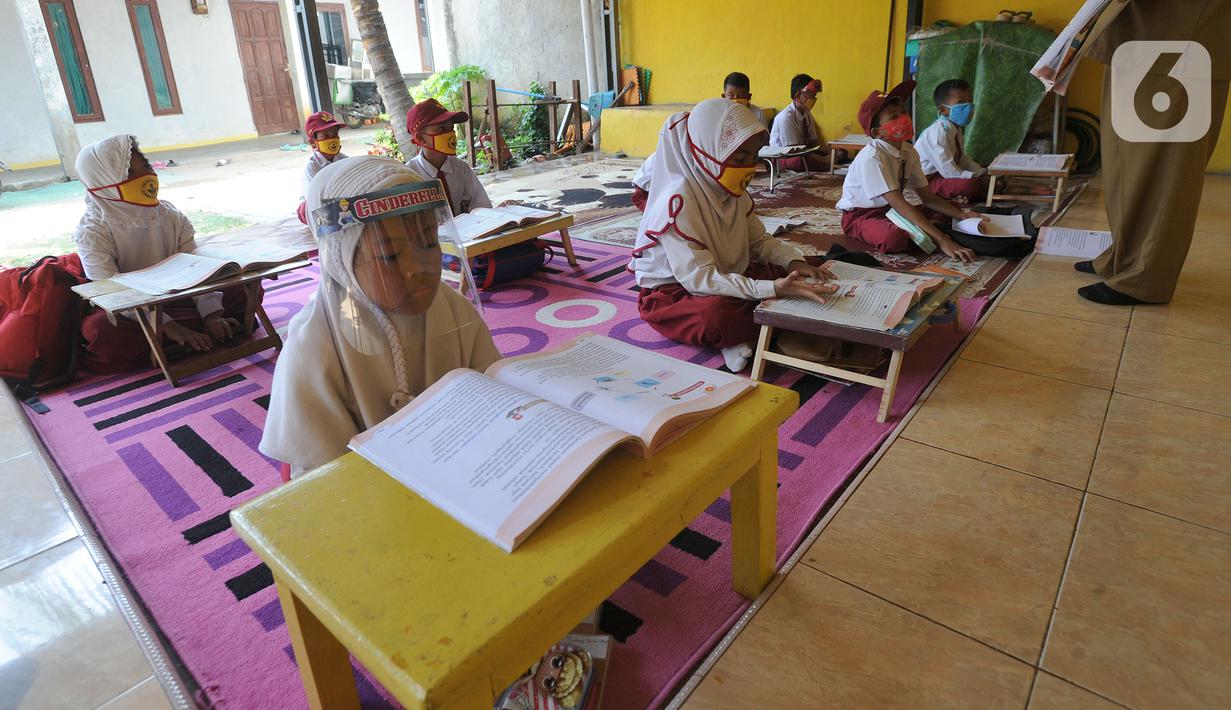Murid kelas III SDN 02 Pondok Petir mengikuti kegiatan belajar mengajar di teras rumah salah satu siswa di Depok, Senin (31/08/2020). Sudah hampir dua minggu ini, mereka mengadakan pembelajaran secara tatap muka dengan guru yang berkeliling atas permintaan wali murid. (merdeka.com/Arie Basuki)