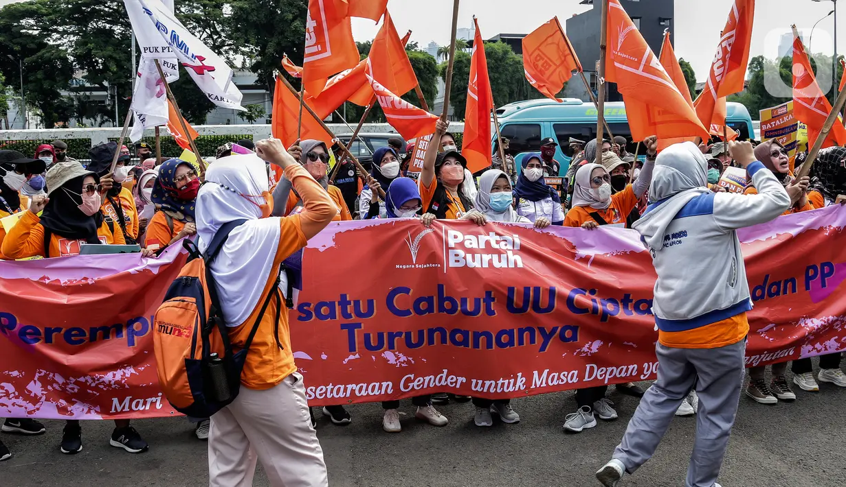 Sejumlah buruh perempuan memegang poster saat menggelar aksi di depan gedung DPR RI, Jakarta, Selasa (8/3/2022). Mereka menuntut dibatalkannya Omnibus Law UU Cipta Kerja dan mendesak agar RUU Tindak Pidana Kekerasan Seksual (TPKS) segera disahkan oleh DPR RI. (Liputan6.com/Johan Tallo)