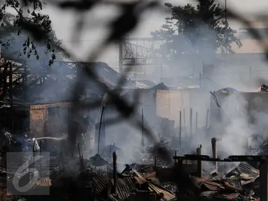 Warga mencoba memadamkan api saat kebakaran di kawasan padat penduduk Bukit Duri, Jakarta, Kamis (24/12). Kebakaran yang menghanguskan sekitar 70 petak rumah itu masih dalam penyelidikan pihak terkait. (Liputan6.com/Helmi Afandi)