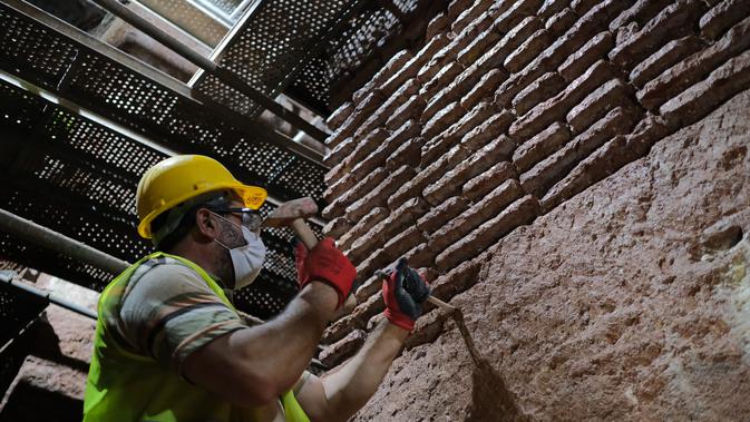 Seorang anggota tim restorasi bekerja di 