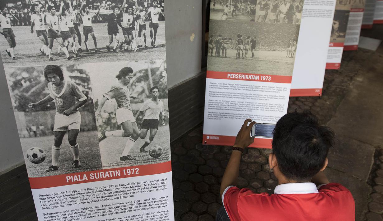Pengunjung memperhatikan cerita-cerita saat pameran foto memperingati hari jadi Persija Jakarta di Lapangan Banteng, Jakarta, Jumat (28/11/2015). (Bola.com/Vitalis Yogi Trisna)
