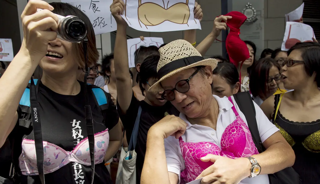 Pengunjuk rasa memakai bra di luar markas polisi di kawasan Wan Chai, Hong Kong, Minggu (2/8). Demo tersebut merupakan aksi simpati terhadap seorang perempuan yang di penjara karena dituduh menyerang polisi menggunakan payudaranya. (REUTERS/Tyrone Siu)
