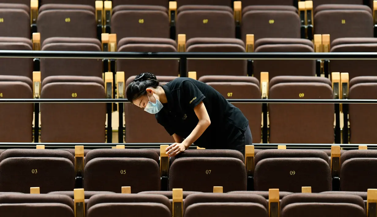 Seorang staf mendisinfeksi kursi-kursi penonton di Tianjin Grand Theater di Tianjin, China utara, pada 28 Juli 2020. Gedung pertunjukan teater itu telah memulai proses disinfeksi menyeluruh selama sepekan sejak Senin (27/7) sebelum dibuka kembali untuk pengunjung. (Xinhua/Sun Fanyue)