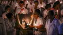 <p>Petugas kesehatan menyalakan lilin untuk menandai Hari Perawat Internasional di sebuah perguruan tinggi kedokteran pemerintah di Chennai, India, Jumat (12/5/2023). (R.Satish Babu/AFP)</p>