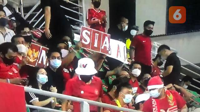 Suporter Timnas Indonesia saat menyaksikan duel melawan Kamboja pada laga perdana penyisihan Grup B Piala AFF 2020 di Stadion Bisham, Singapura. (Bola.com/Ario Yosia)
