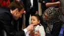 Presiden Prancis Emmanuel Macron menghibur seorang anak saat mengunjungi Graffiti's- Association Le Moulin Vert di Normandia, Prancis (5/4). Pada kunjungannya Presiden Emmanuel Macron berinteraksi dengan anak-anak autis. (AP / Christophe Ena, Pool)