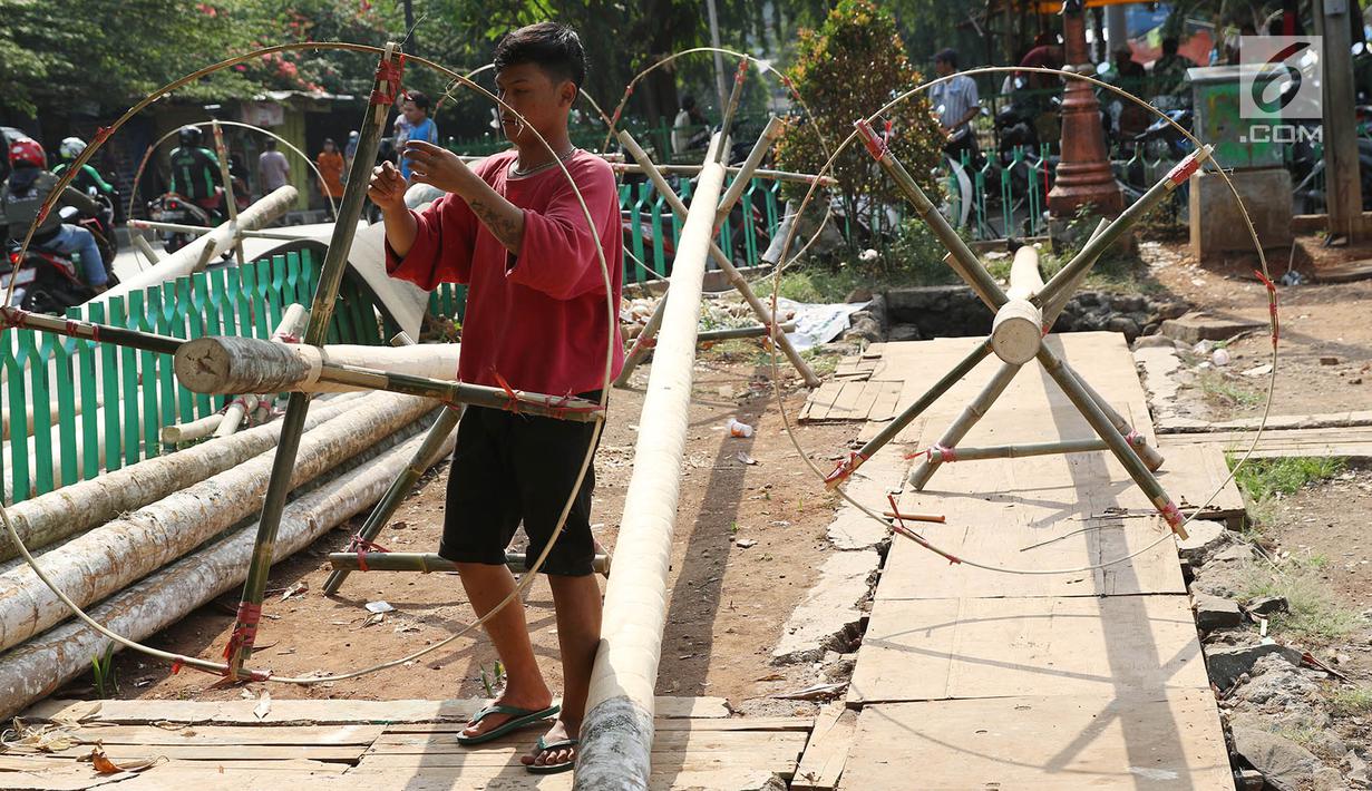 Pedagang menjual batang pohon pinang di kawasan Manggarai, Jakarta, Kamis (3/7). Pohon pinang tersebut dijual seharga Rp900ribu perbatang, yang banyak digunakan untuk meramaikan perlombaan perayaan HUT Kemerdekaan RI. (Liputan6.com/Immanuel Antonius)