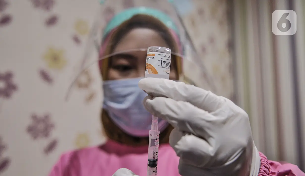 Petugas kesehatan saat mengisi serum vaksin ke dalam jarum suntik di Puskesmas Kecamatan Cilincing, Jakarta, Selasa (23/2/2021). Pemerintah juga melakukan vaksinasi tahap dua untuk petugas pelayanan publik karena dianggap rentan terpapar Covid-19. (merdeka.com/Iqbal S. Nugroho)