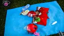 Seorang anak tidur di luar tenda sebuah kamp sementara setelah gempa dan tsunami di Palu, Sulawesi Tengah, Selasa (2/10). Data terbaru BNPB menunjukkan, korban tewas akibat tsunami dan gempa di Sulawesi Tengah sudah mencapai 1.347 orang. (AFP/JEWEL SAMAD)