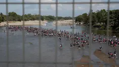 Migran Amerika Tengah menyeberangi Sungai Suchiate dengan berjalan kaki dari Guatemala ke Meksiko, Tecun Uman, Guatemala, Senin (20/1/2020). Lebih dari seribu migran Amerika Tengah yang terdampar di Guatemala berjalan massal untuk menuju Amerika Serikat. (AP Photo/Moises Castillo)